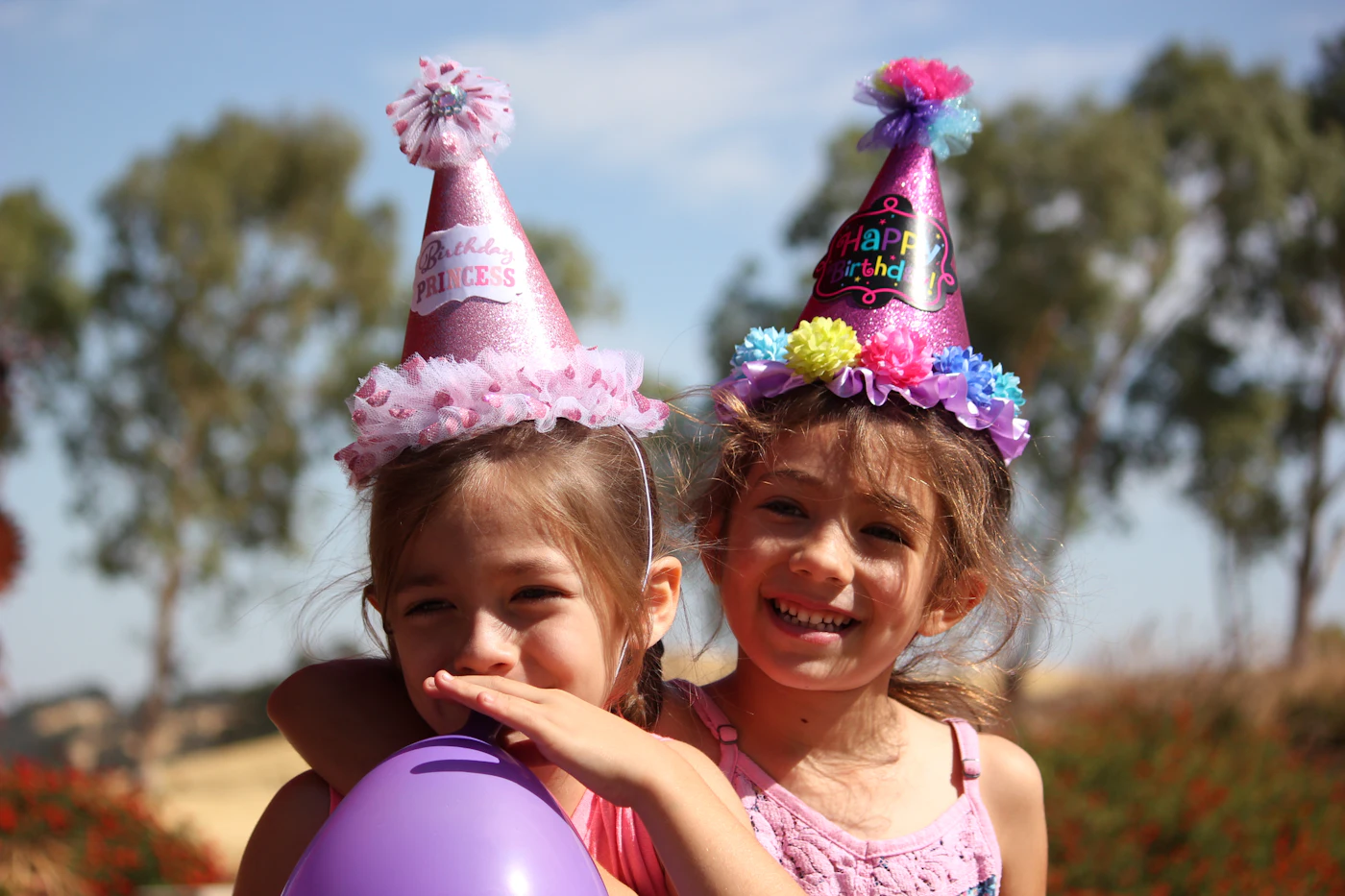 Two girls in birthday party hats at a kids spa party